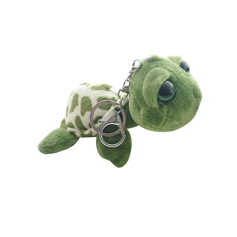 A plush sea turtle keychain with a green head and flippers, a cream and green patterned shell, and a silver metal key ring on a plain white background.